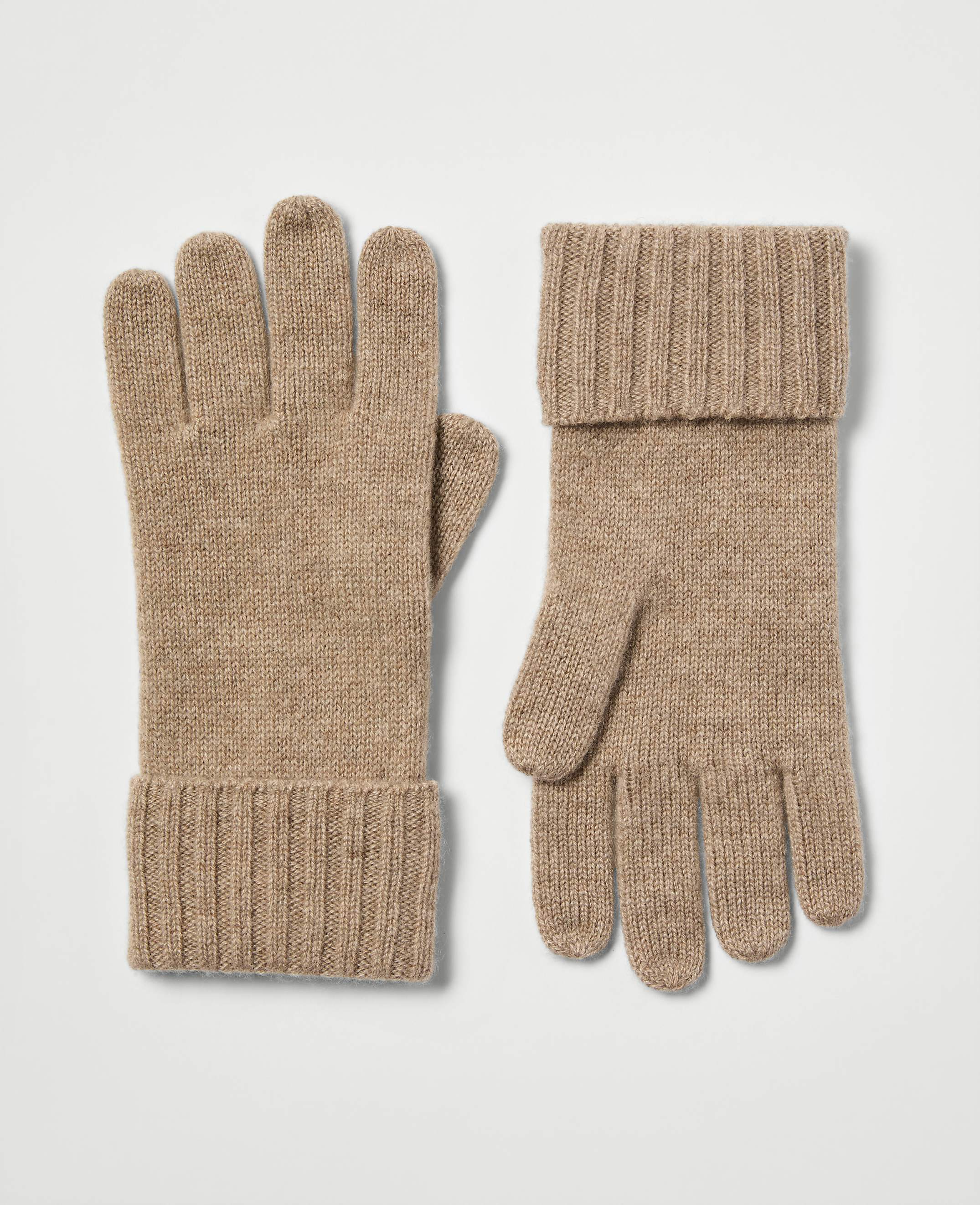 A pair of tan knit gloves with cuffed wrists rests on a plain white background.