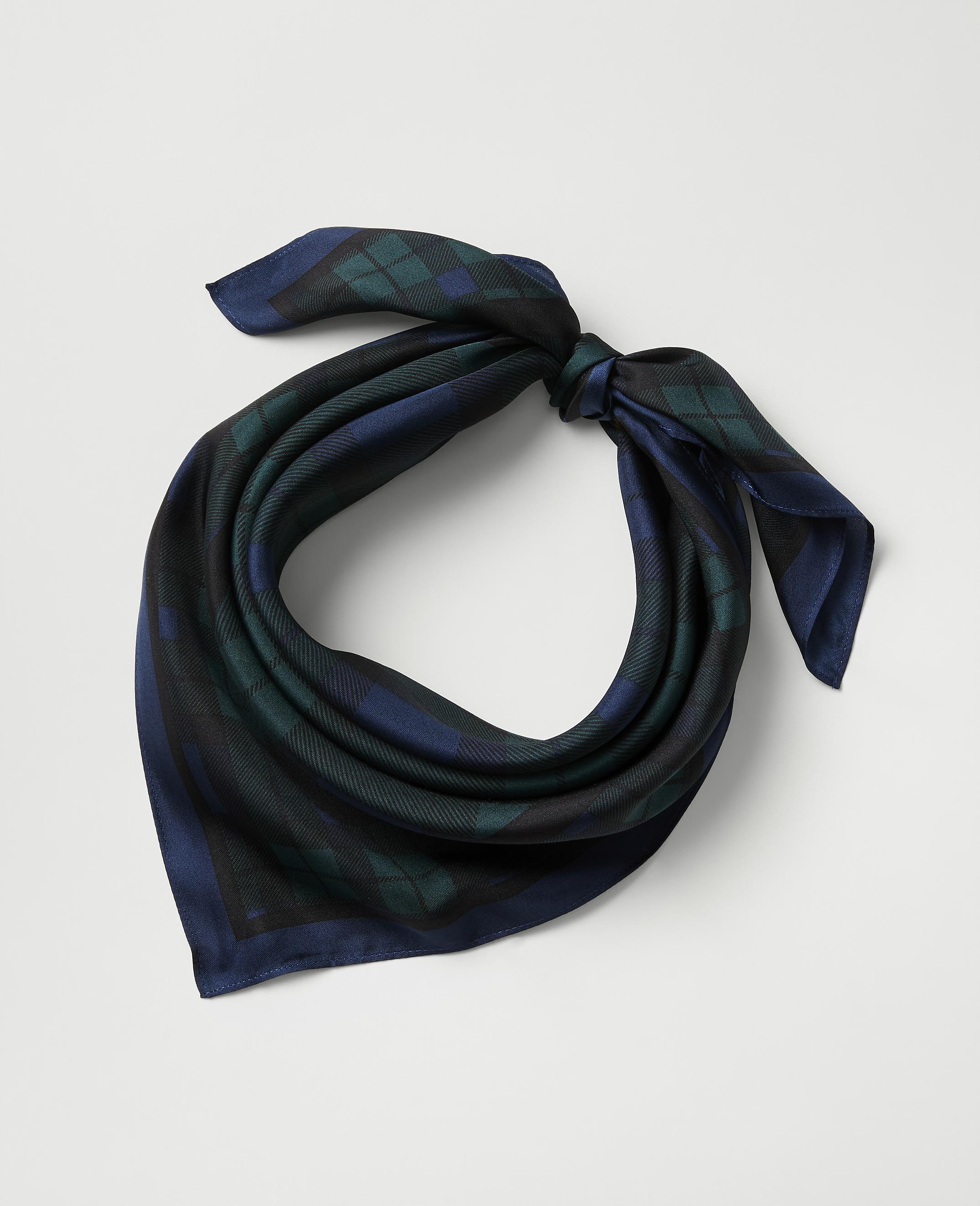 A blue and green plaid silk scarf is tied in a knot against a plain light gray background.