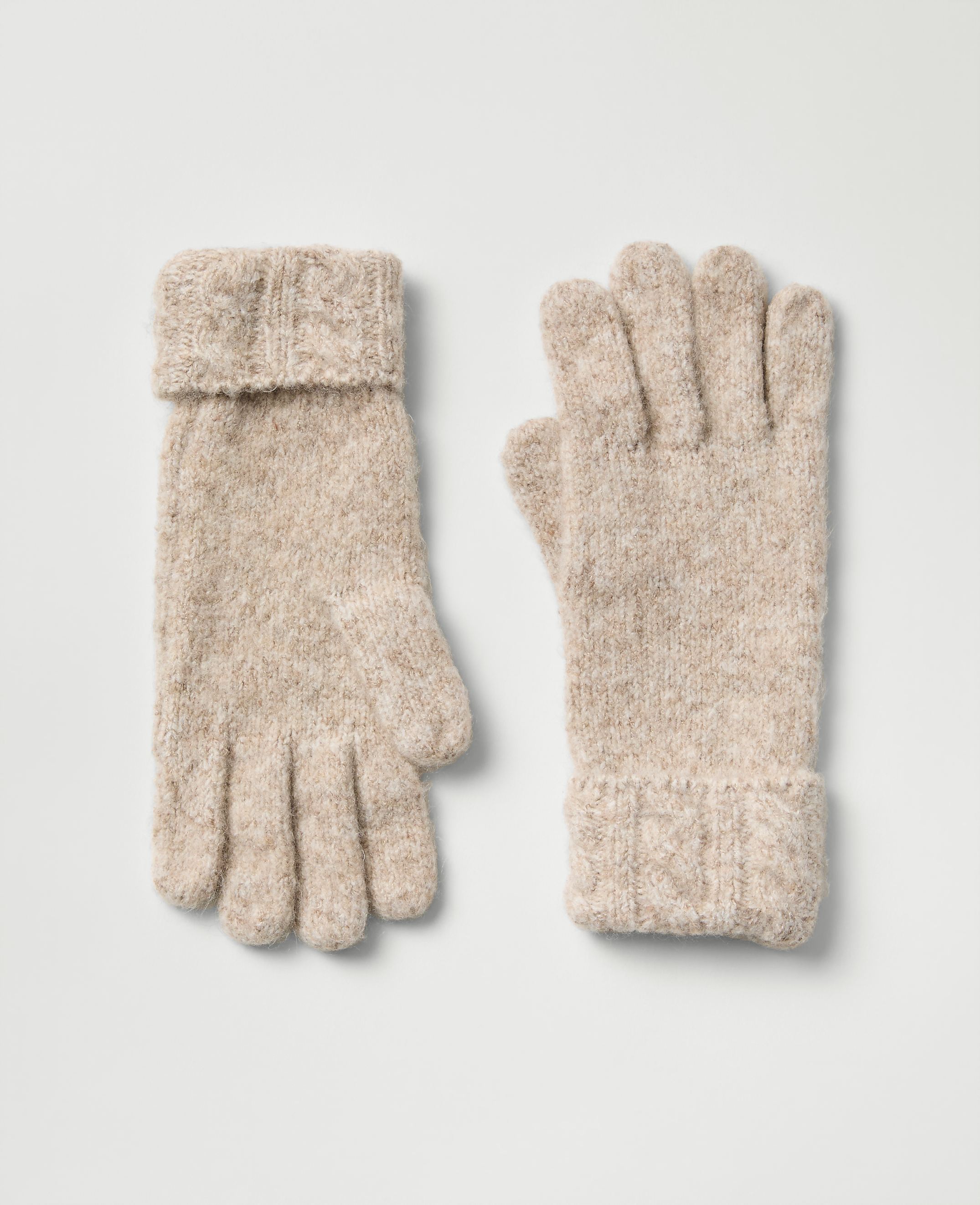 A pair of beige knitted gloves lies flat against a plain light gray background.