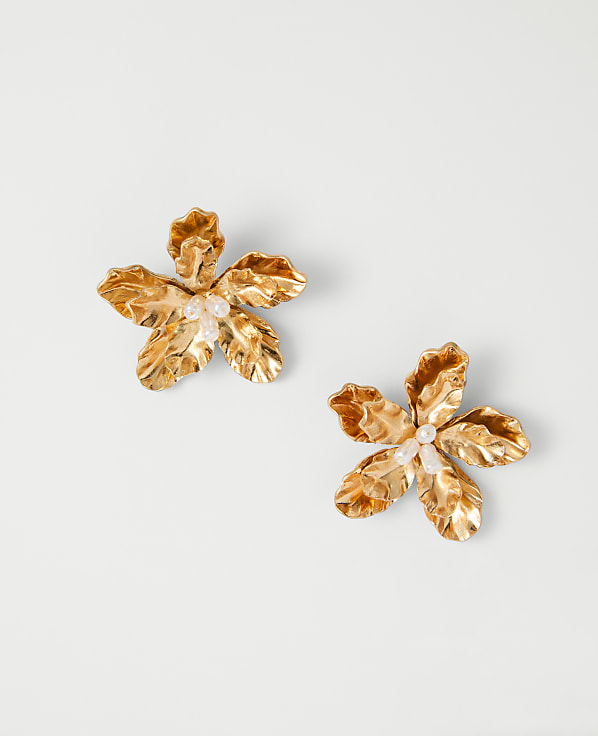 Two golden, flower-shaped objects are displayed against a plain, white background.