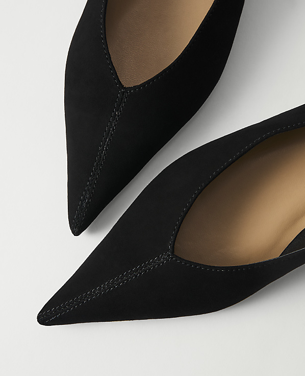 Two black pointed-toe flats with a white background.