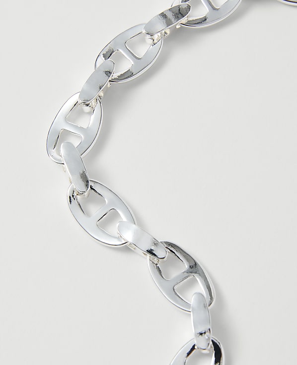 A silver anchor link chain curves across a plain white background.
