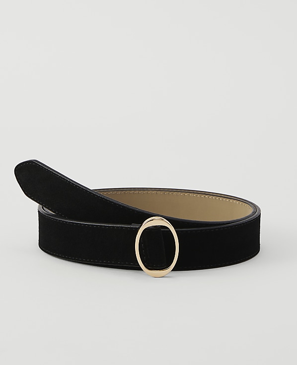 A black suede belt with a gold oval buckle lies on a plain white background.