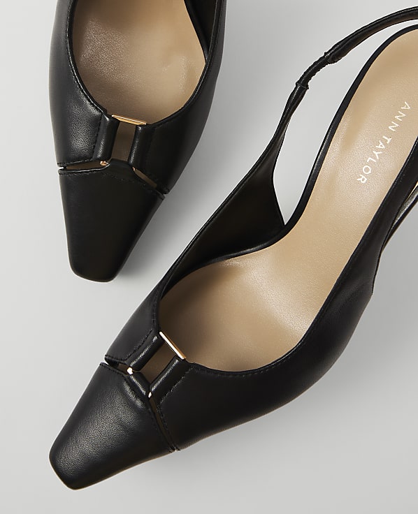 Black slingback heels with gold accents are displayed against a plain white background.