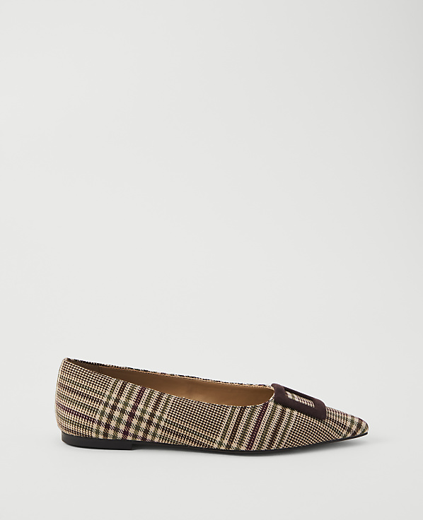 A brown plaid pointed-toe flat shoe with a dark buckle sits on a plain white background.