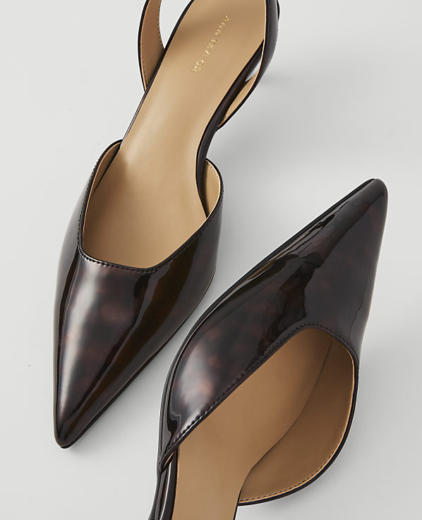 Two glossy, tortoiseshell slingback heels with pointed toes are arranged on a plain white background.