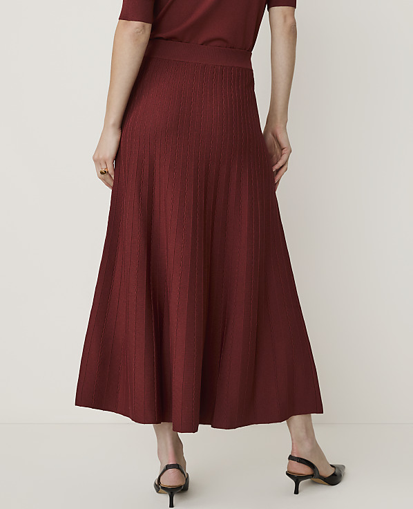 A person wearing a maroon knit midi skirt and black slingback heels stands against a plain white background.