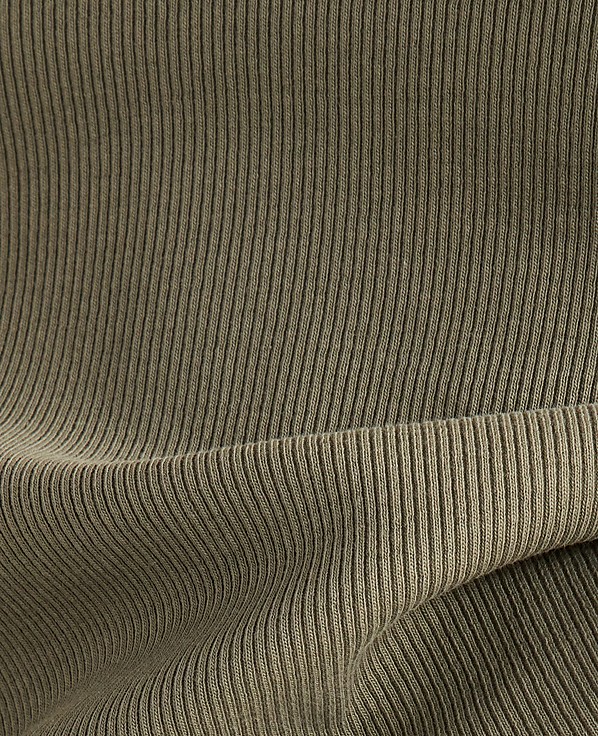 A close-up view of olive green ribbed fabric in the foreground folds over a similar textured background.