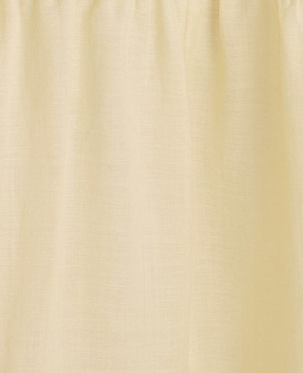 A pale yellow curtain with soft folds hangs in front of a subtly textured, lighter background.