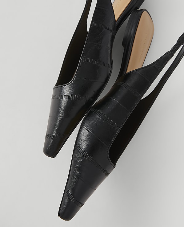 Two black slingback heels with a textured finish are angled against a plain white background.
