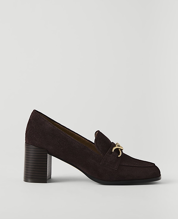 A dark brown suede loafer with a gold buckle sits on a plain white background.