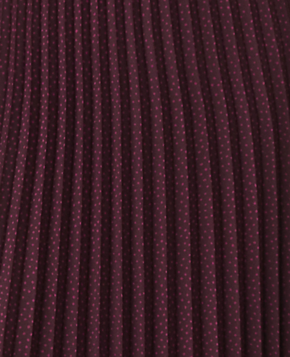 A close-up view of a burgundy pleated fabric with a subtle polka dot pattern fills the frame.