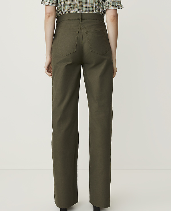 A person wearing olive green pants stands against a plain white background.