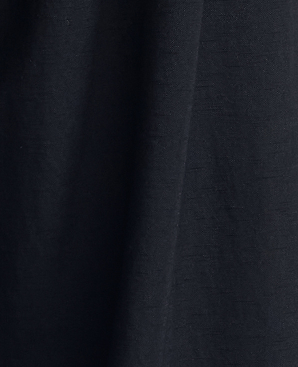 Dark blue fabric with subtle texture fills the frame, with soft folds creating shadows and highlights.