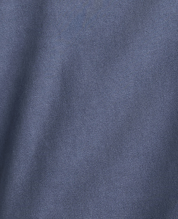 A close-up of a textured blue fabric fills the frame, with subtle folds and shadows creating depth.