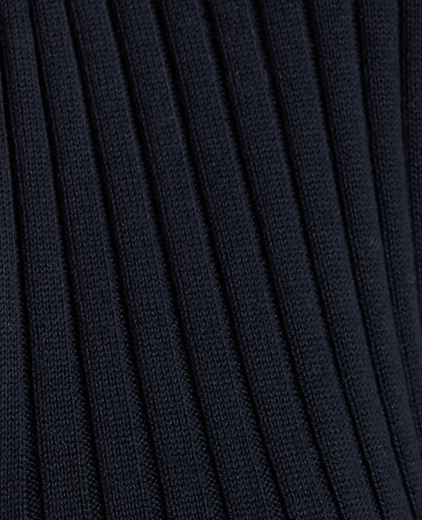 A close-up view of dark navy ribbed fabric fills the frame, with the texture of the knit creating a repeating pattern of raised lines.