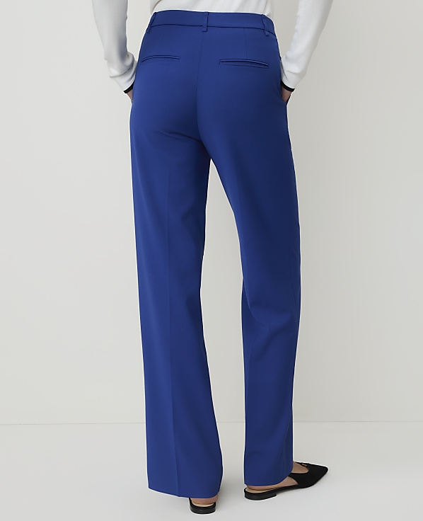 A person wearing bright blue wide-leg trousers and black flats stands against a plain white background.