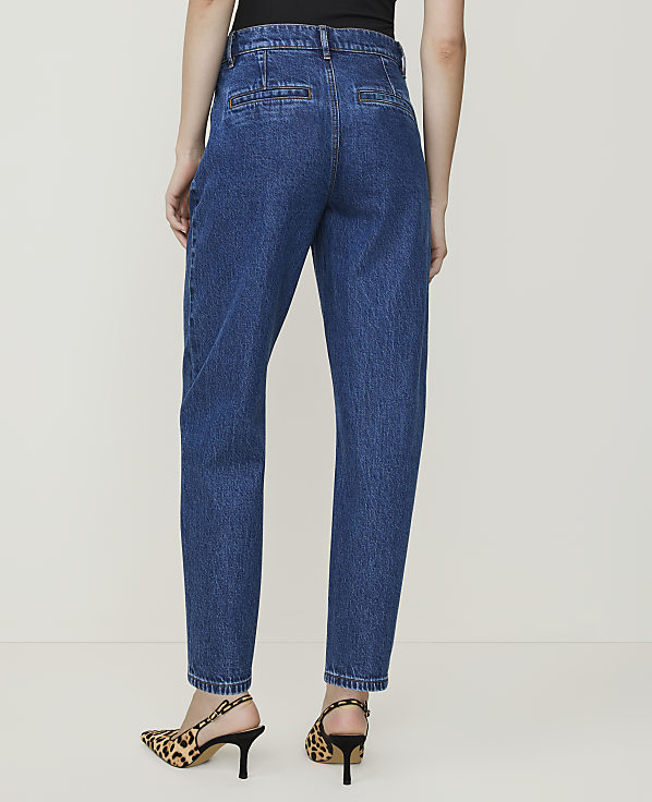 A person wearing blue denim jeans and leopard print heels stands against a plain white background.