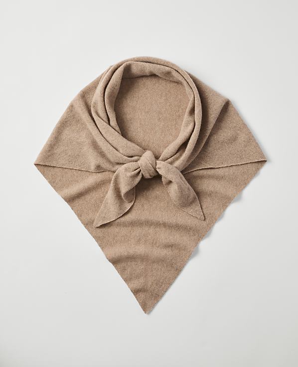 A tan cashmere scarf is knotted in the foreground against a plain white background.