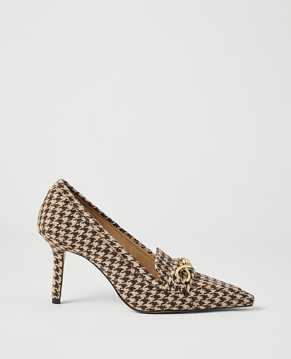A brown and tan houndstooth pump with a gold buckle sits on a plain white background.