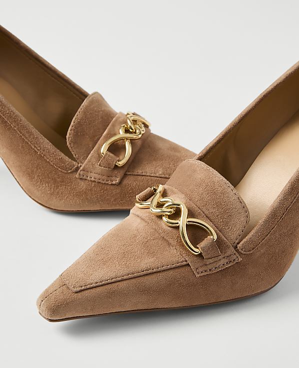 A pair of tan suede loafers with gold chain accents are displayed against a plain white background.
