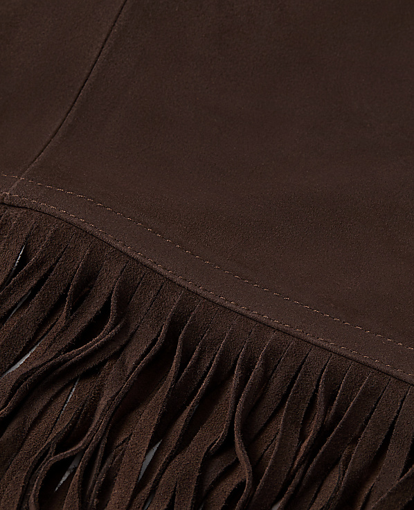 Brown suede fabric with fringe in the foreground and a plain background.
