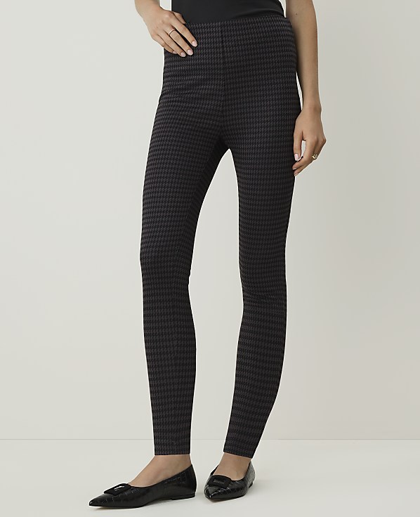 A person wearing patterned leggings and black flats stands against a plain, light-colored background.