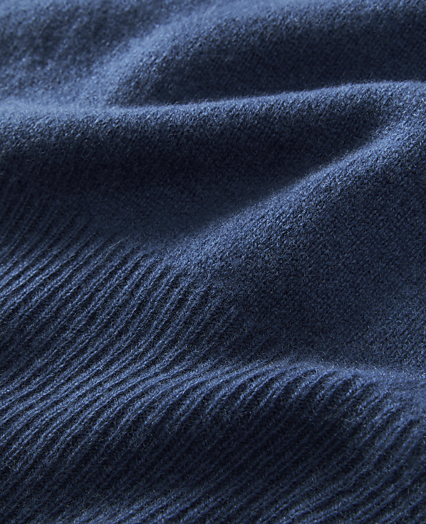 Deep blue, textured fabric folds in the foreground against a softly blurred background.