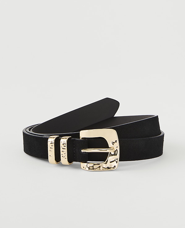A black suede belt with a hammered gold buckle and three gold loops rests on a plain white background.