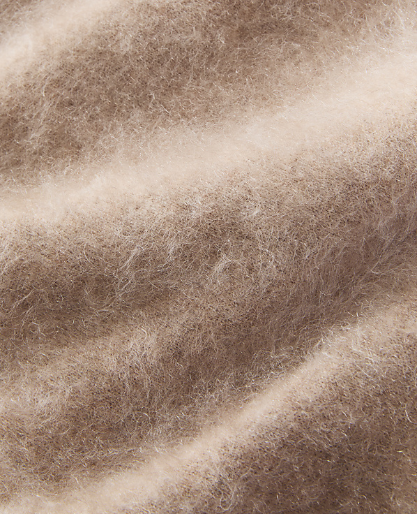 Soft, fuzzy brown fibers create a textured foreground against a lighter, blurred background.