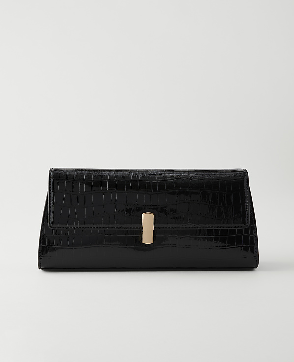 A glossy black crocodile-embossed clutch with a gold clasp rests on a plain white background.