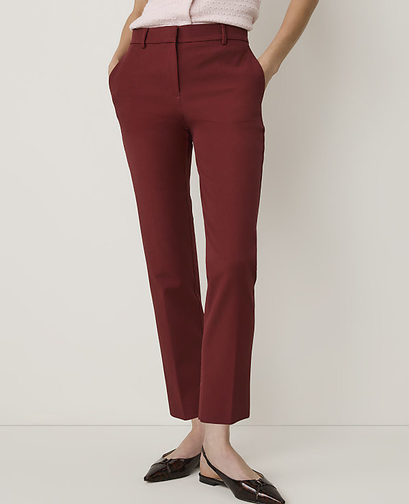 A person in maroon cropped pants and a pink top stands against a plain white background.