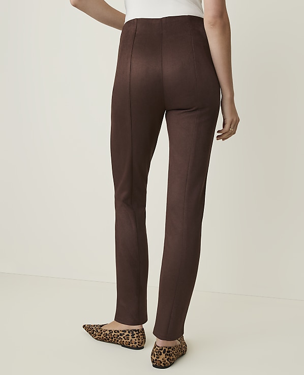 A person wearing brown leggings and leopard print flats stands against a plain, light-colored background.