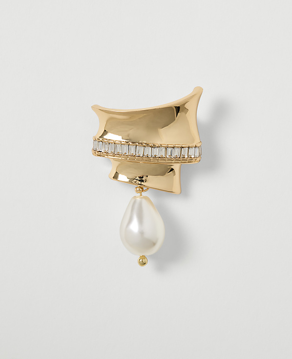 A gold brooch with a pearl drop and crystal accents is displayed against a plain white background.