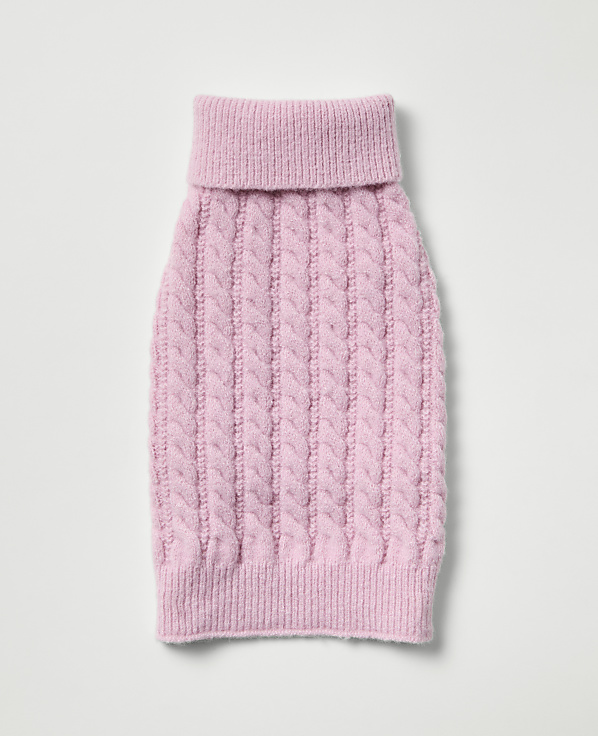 A pink cable-knit dog sweater with a turtleneck lies flat against a plain white background.