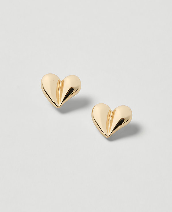 Two golden heart-shaped earrings rest on a light gray background.