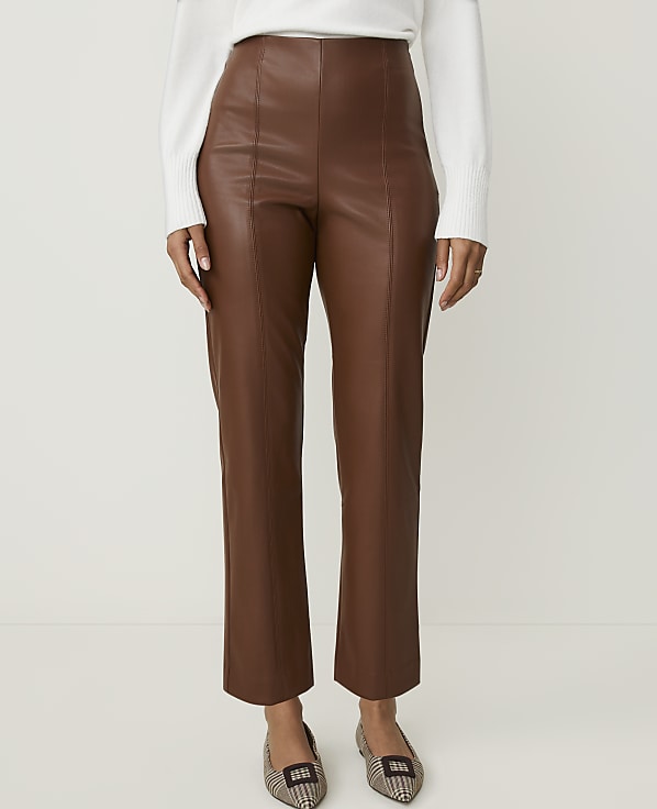 A person stands in brown leather pants and patterned flats against a plain white background.