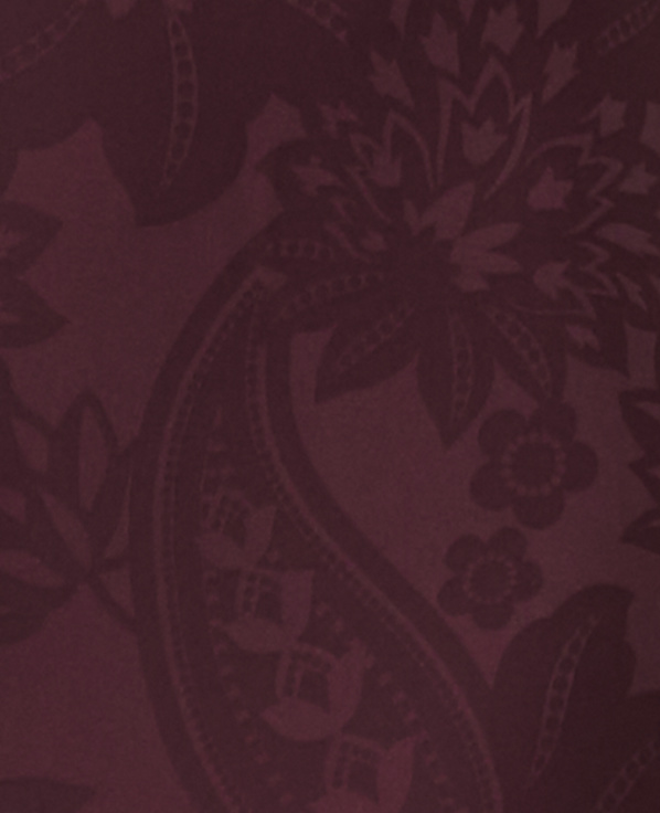 A dark red paisley pattern with floral elements fills the frame.