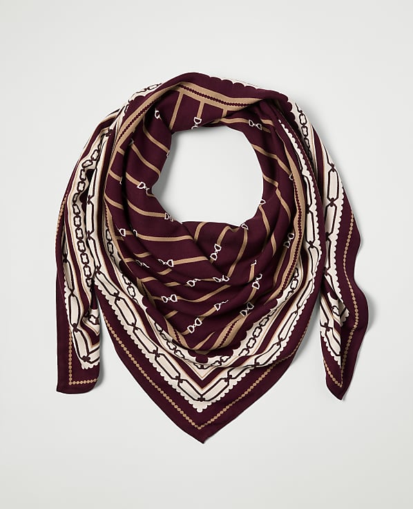 A maroon scarf with a chain link pattern is laid flat against a plain white background.