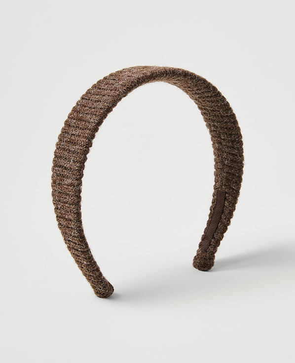 A brown ribbed headband rests on a plain white background.