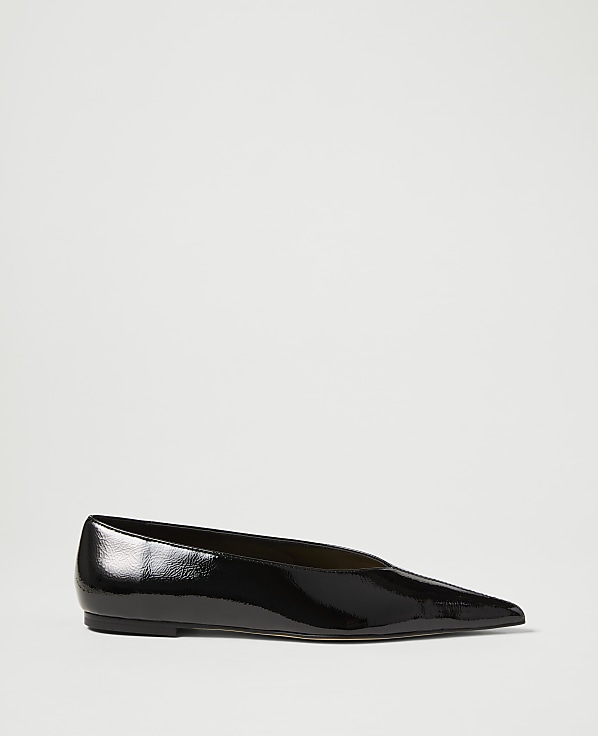 A glossy black pointed-toe flat shoe rests on a plain white background.