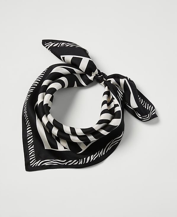 A black and white striped bandana is tied in a knot in the foreground, set against a plain white background.