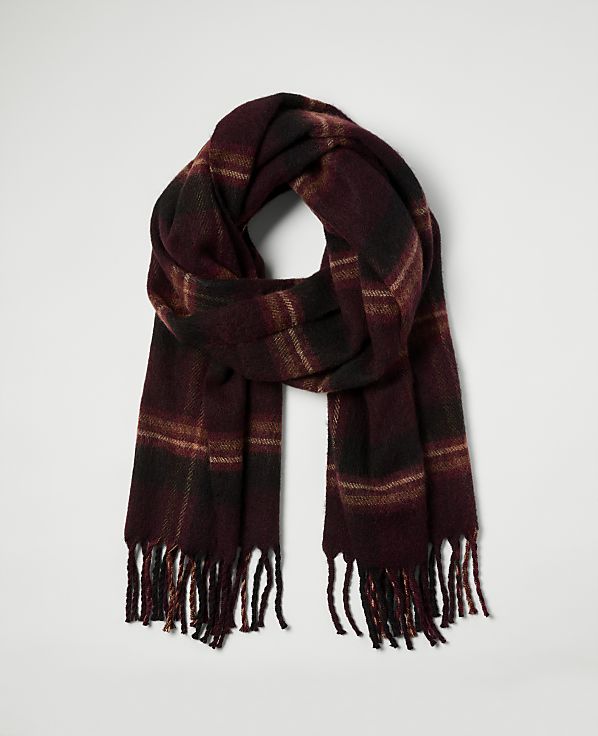 A burgundy plaid scarf with fringe hangs against a plain white background.