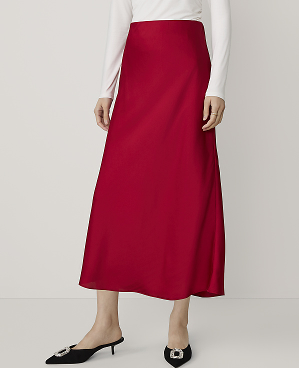 A person in a red satin skirt and white top stands against a plain white background.