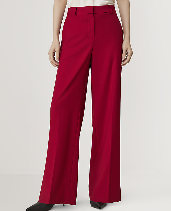 A person in bright red wide-leg trousers stands against a plain white background.