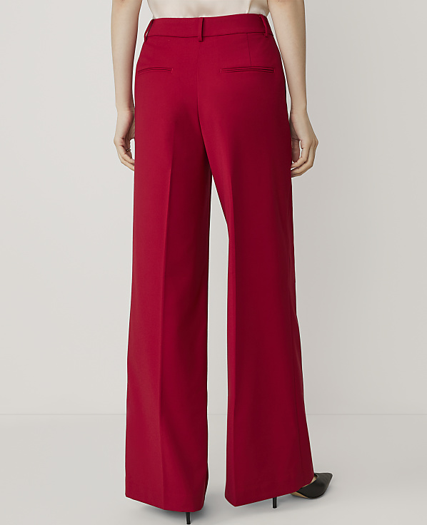 A person wearing red wide-leg trousers stands against a plain white background.