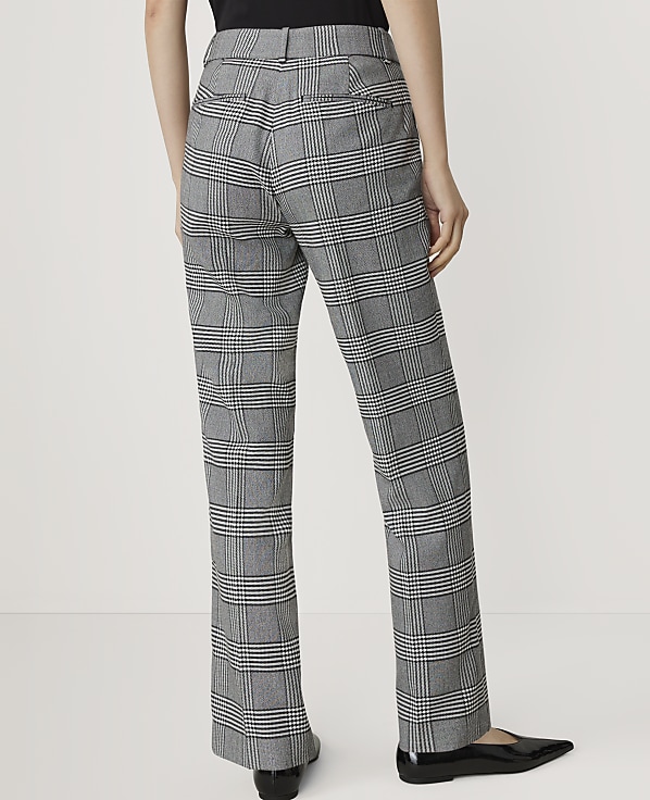 A person wearing plaid pants stands against a plain white background.
