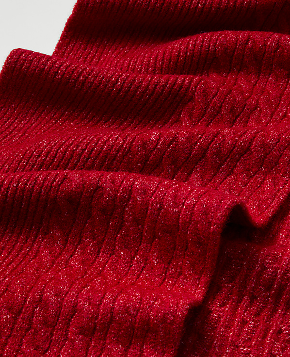 A textured red knitted fabric folds across the foreground against a plain white background.