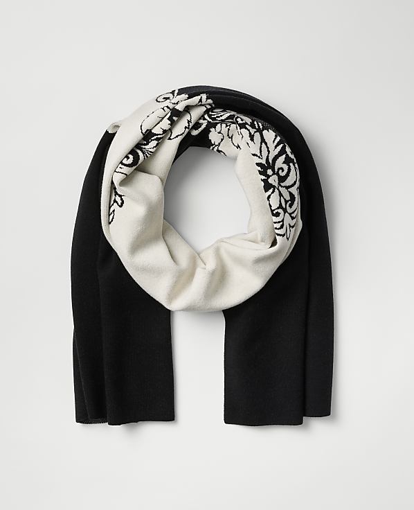 A black and white patterned scarf is centered against a plain light gray background.