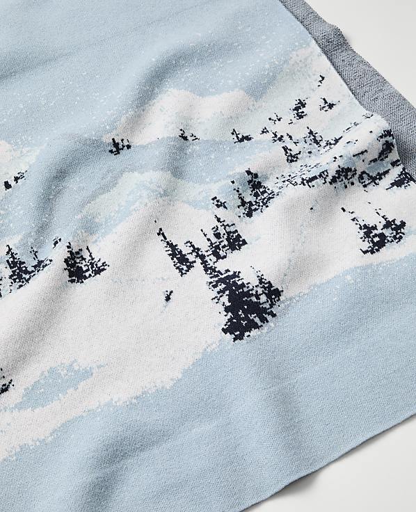 A light blue fabric features a white and navy blue landscape pattern of snowy mountains and pine trees.